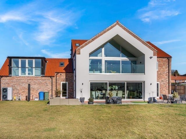 Looking back at the six-bedroom property from its rear lawned garden.