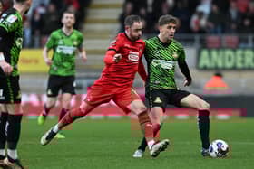 Harrison Biggins wins a challenge in midfield against Leyton Orient.