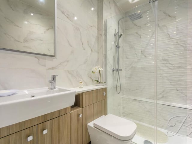 The master bedroom at the Tor Lane property has the added luxury of this stylish en suite. It comes complete with a chrome rainfall shower, wash hand basin, low-flush WC and full height tiling.