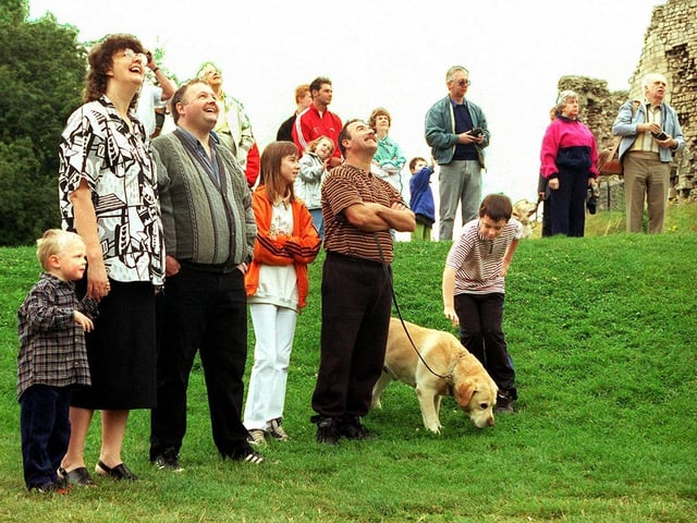 Early risers keep their eyes peeled skywards as the last of the hot air balloons rises above Conisbrough Castle in August 1998
