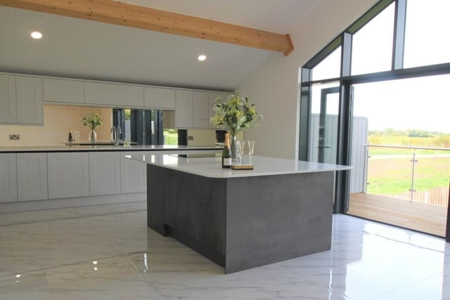 The first floor living and dining kitchen has double doors out to a balcony, with rural views.