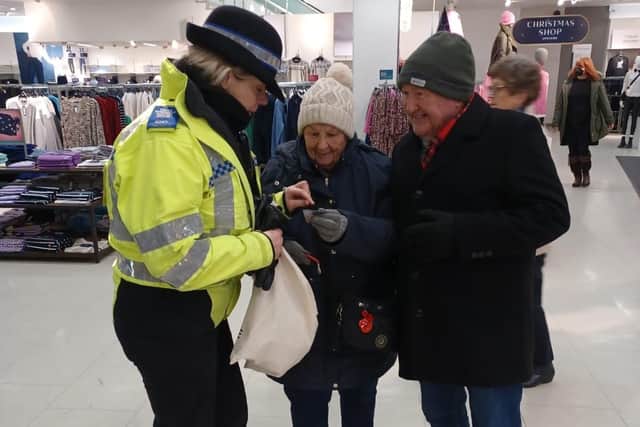 An officer engages with shoppers