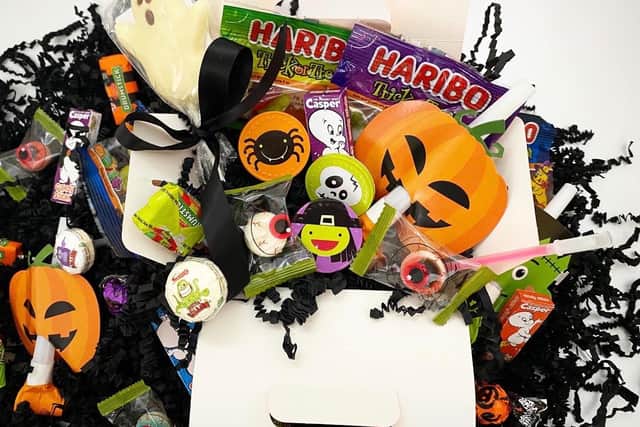The boxes include a variety of treats from packets of sweets to glow sticks and spooky stickers.