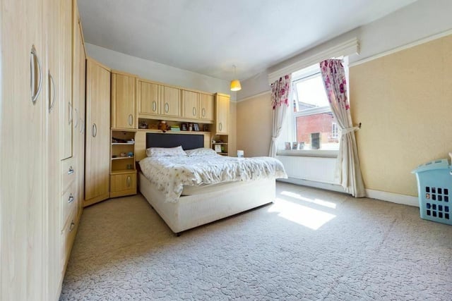 A spacious bedroom with fitted furniture.