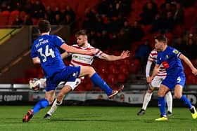 Doncaster's George Miller has a pop at goal.