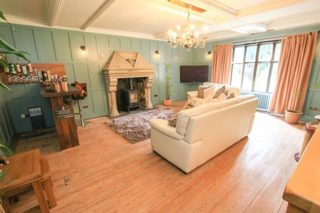 Wall panelling and a stunning fireplace are features within this more cosy room.