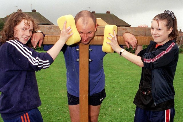 Balby Carr school teacher Dave Williams is in the stocks at the Community Day at Balby Carr school, Doncaster - Katie and Kerry were manning the stocks, July 3, 1999