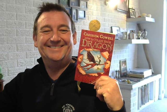 Alan Roberts holding the How to Train your Dragon book.