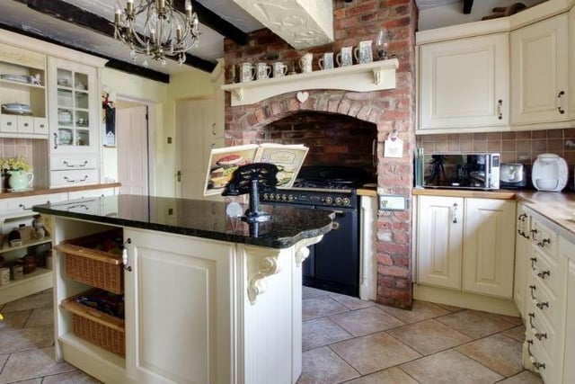 A rustic-style kitchen with central island and range cooker.