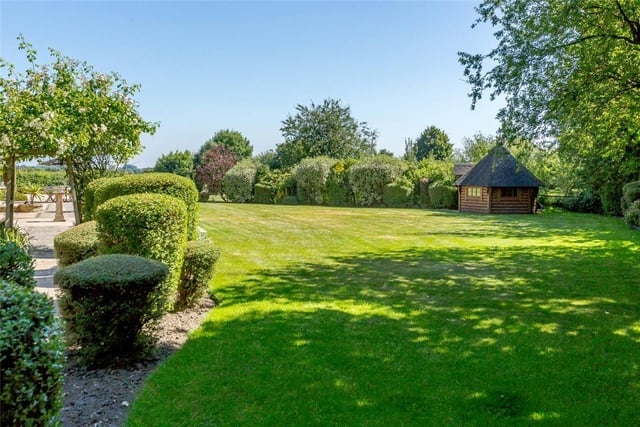 Enclosed private gardens surround the property, which extends across 6,500 sq ft, and includes manicured lawns, hedges, mature beds, a paved terrace, orchard and barbecue house.
