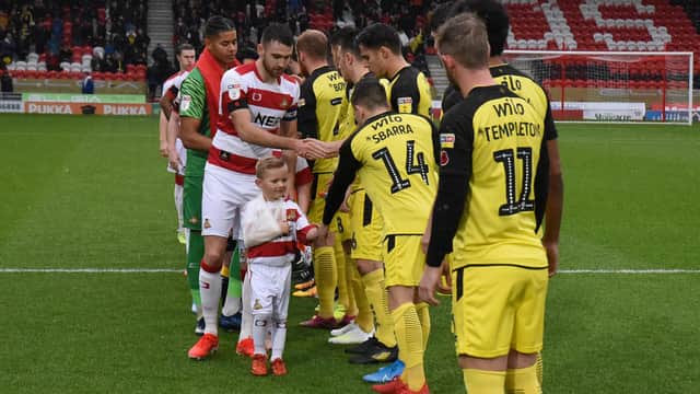 Doncaster Rovers carry out their pre-match handshake with Burton Albion