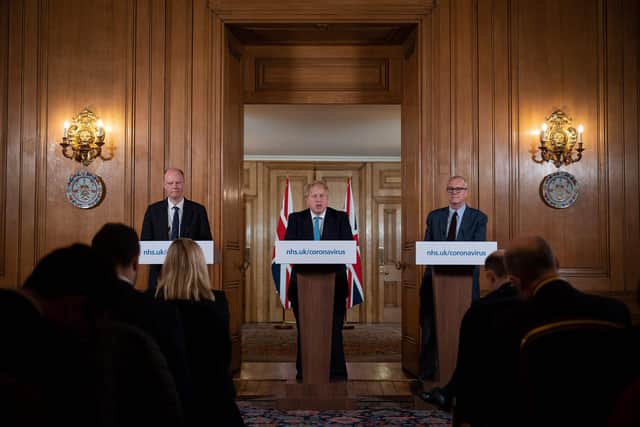 Chief Medical Officer Chris Whitty (L) and Chief Scientific Adviser Patrick Vallance (R) look on as Britain's Prime Minister Boris Johnson addresses a news conference (Photo by LEON NEAL/POOL/AFP via Getty Images)