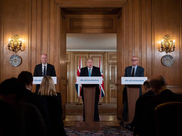 Chief Medical Officer Chris Whitty (L) and Chief Scientific Adviser Patrick Vallance (R) look on as Britain's Prime Minister Boris Johnson addresses a news conference (Photo by LEON NEAL/POOL/AFP via Getty Images)