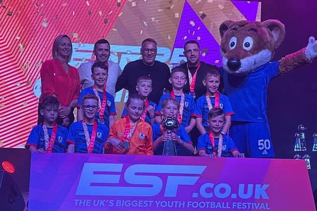 Barnby Dun Colts Under-9s receive their trophy from former Arsenal and England man Paul Merson.