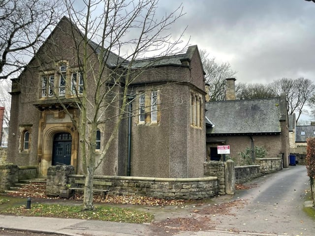 A stone wall runs around the property, with steps up to the imposing front entrance.