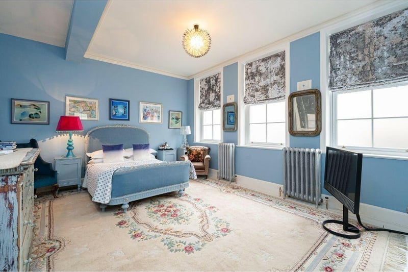 A blue bedroom, with beamed ceiling.