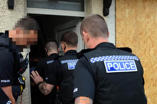 File pictures of police carrying out a drug raid on a house