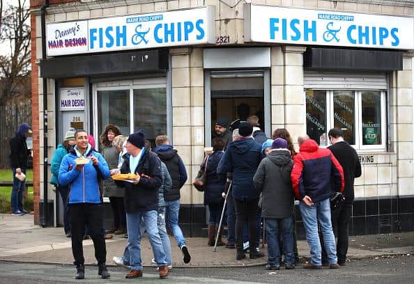 People enjoying a traditional serving of fish and chips.