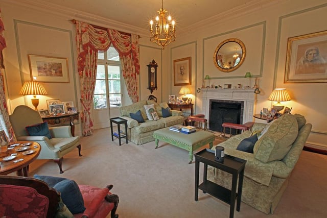 The drawing room has high ceilings, an Adam style fireplace with inset working grate, a bar incorporated into a cupboard  and double French door to the conservatory.