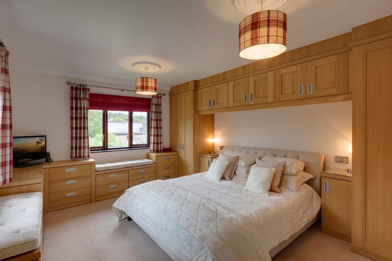The master suite is described as generously sized with side and rear facing timber double glazed windows. There’s a comprehensive range of fitted furniture by Hammonds, which incorporates short/long hanging, shelving, drawers and two window seats.