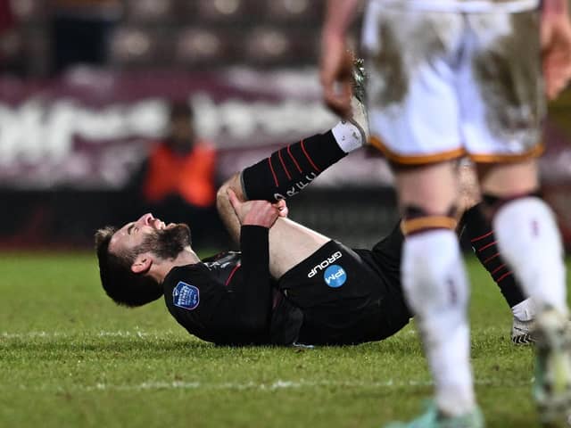 Doncaster's Ben Close clutches his knee after a challenge late on in the defeat at Bradford.