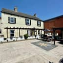 The front of the farmhouse, with patio area and bespoke bar to one side.