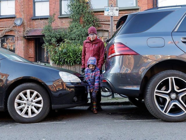 A family forced to squeeze past a supersized SUV.