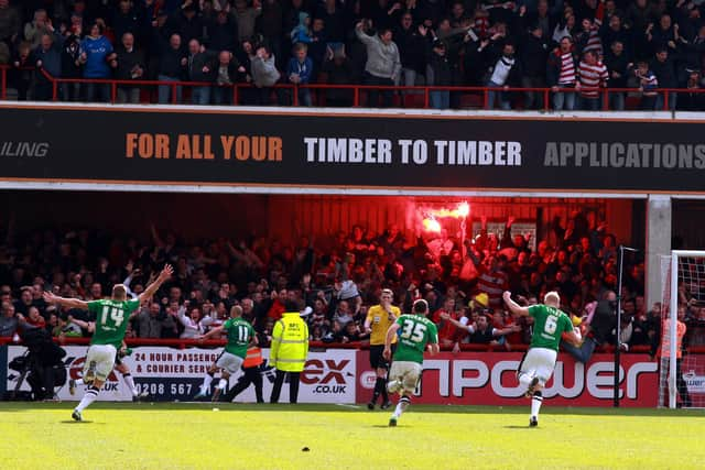 The Rovers players chase after James Coppinger after his title-sealing goal in front of supporters