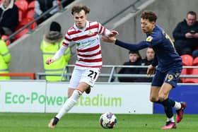 Doncaster's Kyle Hurst dribbles past Wimbledon's Kasey McAteer.