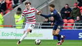 Doncaster's Kyle Hurst dribbles past Wimbledon's Kasey McAteer.