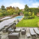 The property's attractive garden that includes a heated swimming pool.