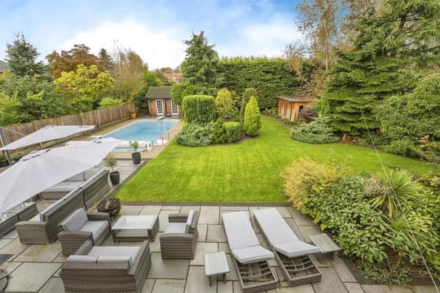 The property's attractive garden that includes a heated swimming pool.