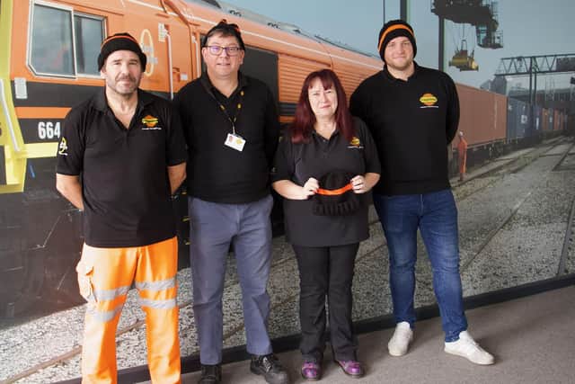 Freightliner Train Service Controller Karen Gyte (second right) is pictured with colleagues in their knitted hats.