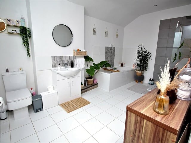 The contemporary style bathroom includes a bath and a separate shower unit.