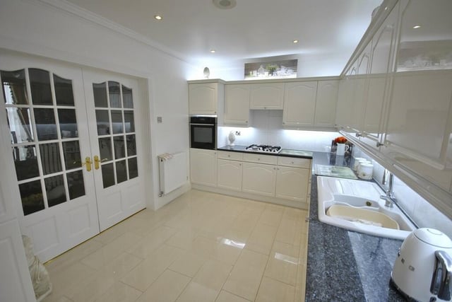 The kitchen has extensive fitted units with integrated appliances.
