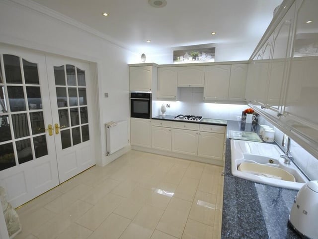 The kitchen has extensive fitted units with integrated appliances.