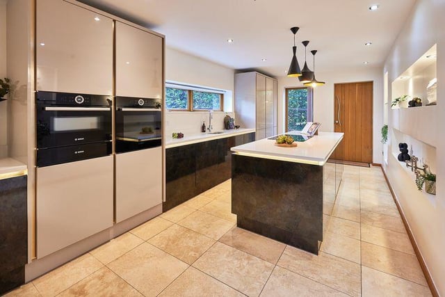 The sleekly styled kitchen includes a breakfast peninsular and a central island with induction hob.