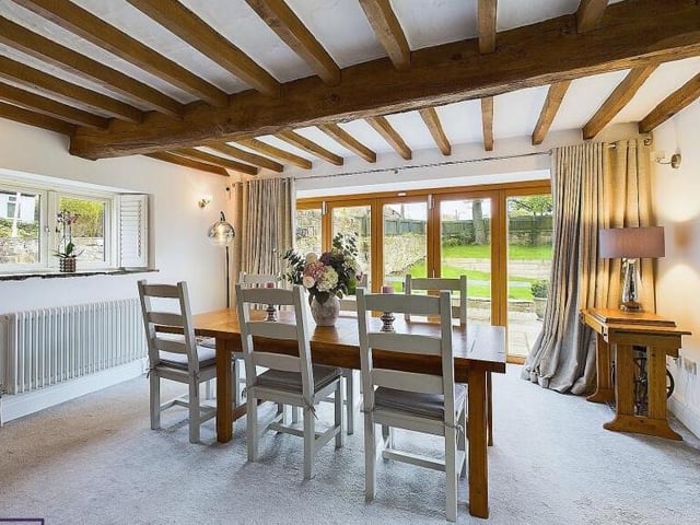 The beamed dining room, with doors leading out to the garden.