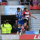 Doncaster's Tom Nixon goes up for a header with Sheffield Wednesday's Josh Windass.