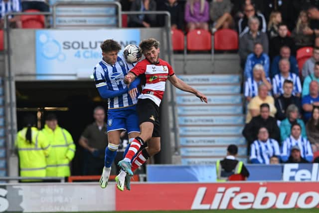 Doncaster's Tom Nixon goes up for a header with Sheffield Wednesday's Josh Windass.