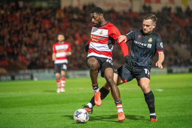 HOLDING ROLE: Doncaster Rovers forward Hakeeb Adelakun keeps Luke Bolton at bay