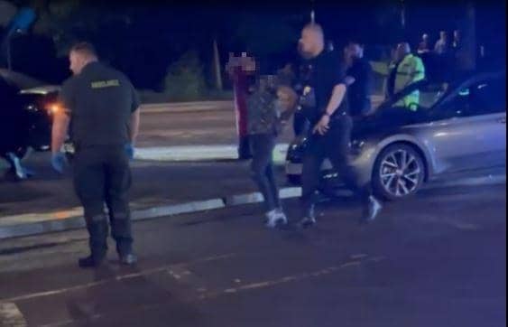 A man is led away from the scene by officers. (Photo: Matthew Cook).