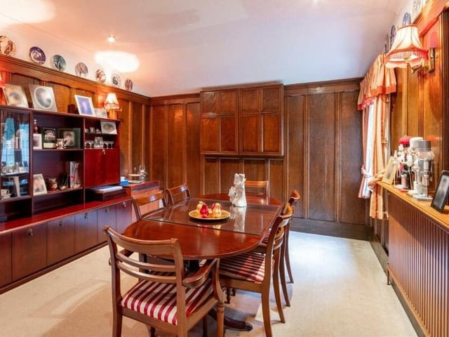 The formal dining room with wood panelling to the walls.