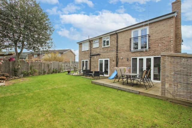 A rear view of the property from the garden, with seating areas.