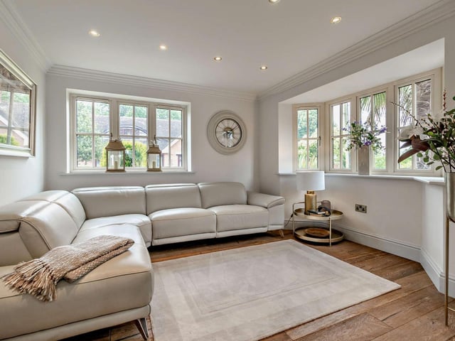A double aspect sitting room with wooden flooring.