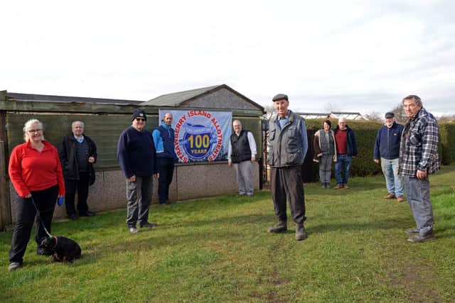 Celebrating 100 years of Strawberry Island Allotments are l-r Marie Jeeves and Tilly, Tony Mulhall, Robin Story, Vice Chairman of the SIAA, Carl Probert, Bob Peace, Charlie Bennett, Chairman of the Strawberry Island Allotments Association, Sandra and Andy Faulkner, Russ Haywood and John Hill. NDFP-09-03-21-StrawberryIsland 2-NMSY