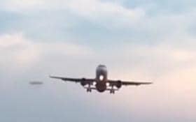 Still picture showing the 'UFO' near a jet arriving at Doncaster Sheffield Airport - now investigators believe they may have solved the riddle