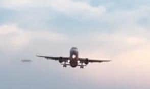 Still picture showing the 'UFO' near a jet arriving at Doncaster Sheffield Airport - now investigators believe they may have solved the riddle