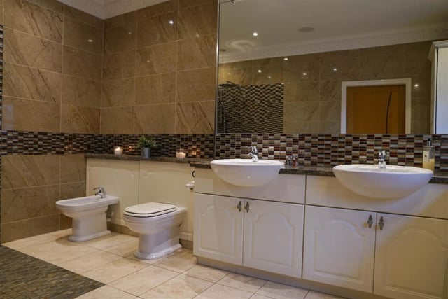 The main bedroom also has its own ensuite, which features granite surfaces and marble flooring.