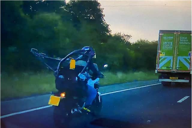 The biker was spotted travelling on the M18 with a motorbike framed strapped to his back.